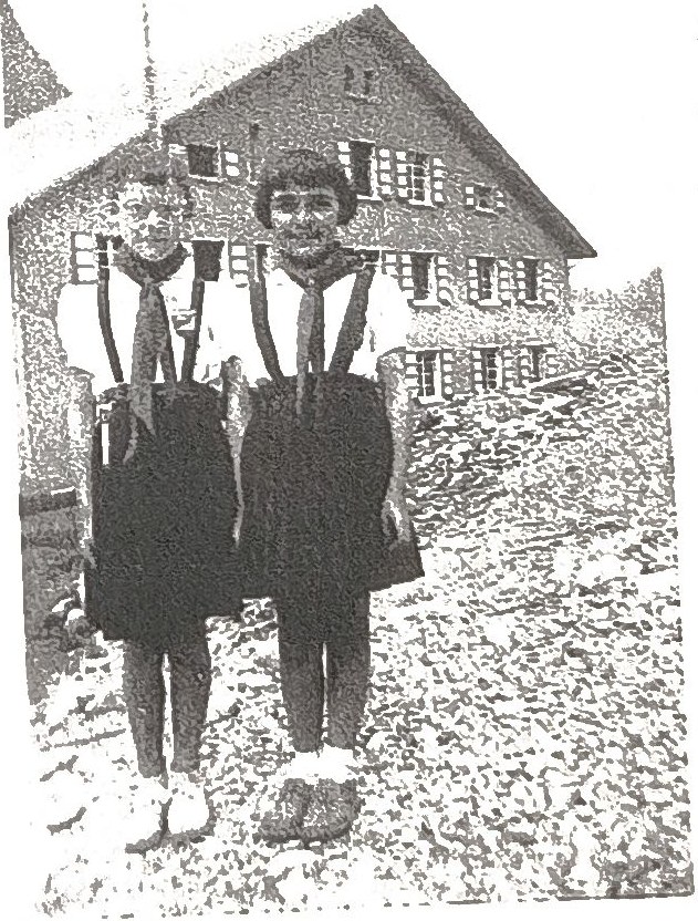 Page 18 de l'album : deux colonnettes en uniforme devant le chalet.