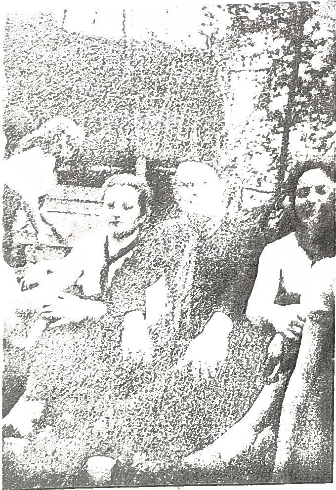 Page 32 de l'album : groupe assis en plein air, daté 1958.