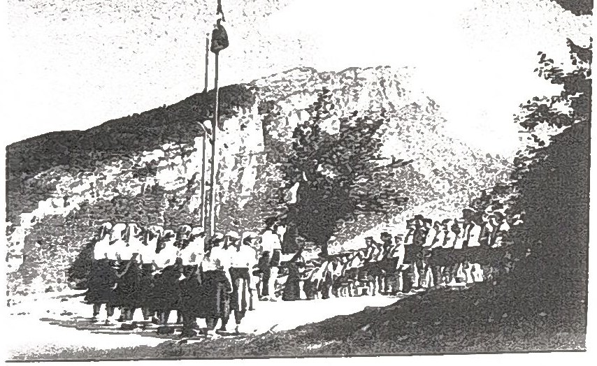 Page 17 de l'album, datée 1956 : rassemblement devant le mât, montagne en arrière-plan.