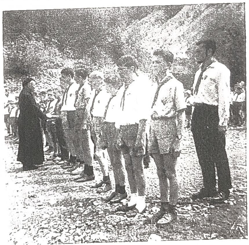 Page 19 de l'album, datée 1962 : garçons en uniforme passés en revue par un prêtre en soutane.