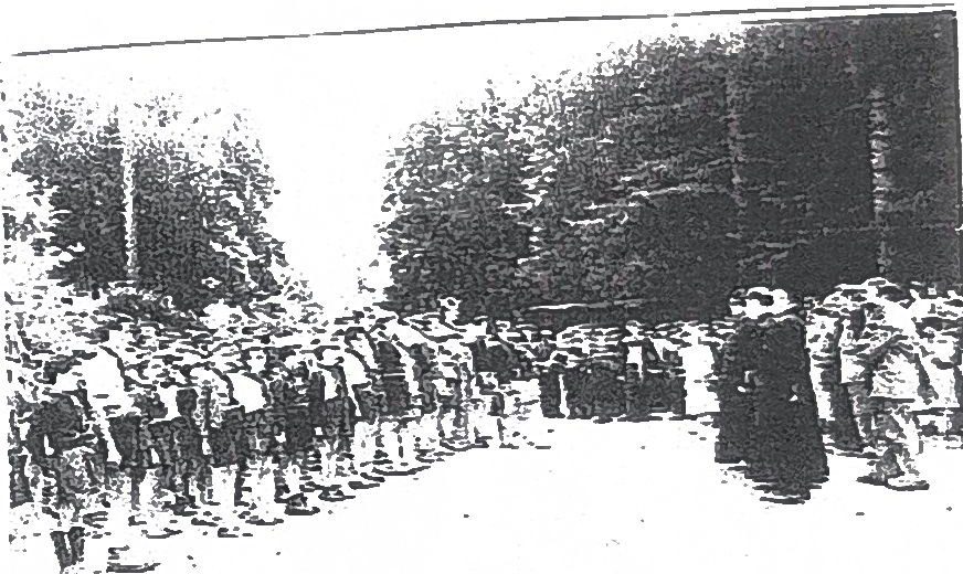 Page 44 de l'album, 1952 : rassemblement en uniforme devant un prêtre.