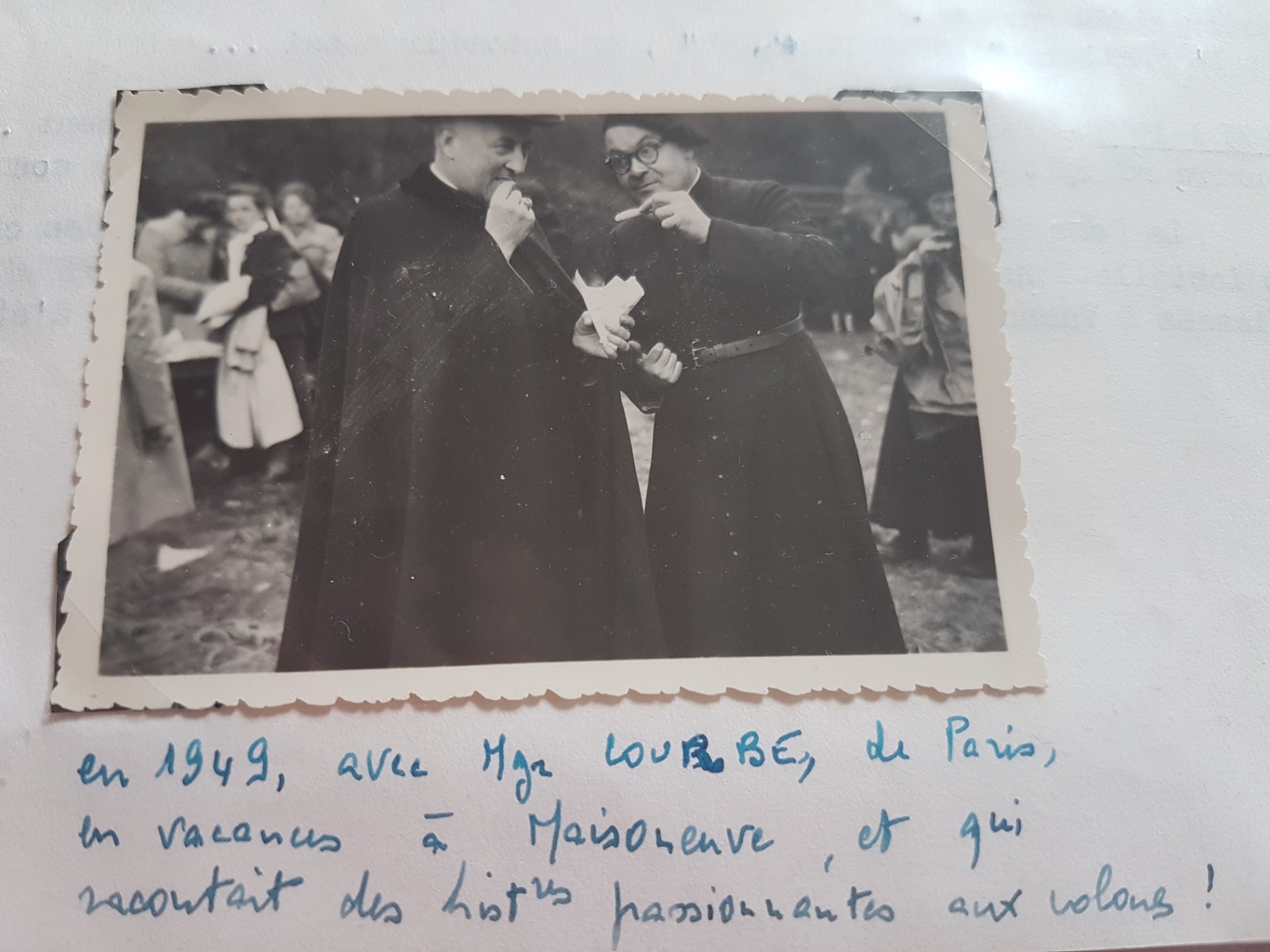 La légende indique « en 1949, avec Mgr LOUTRE, de Paris », en vacances à Maisonneuve et racontant des histoires aux colons. Lecture du nom à confirmer ; l’autre personne n’est pas identifiée.